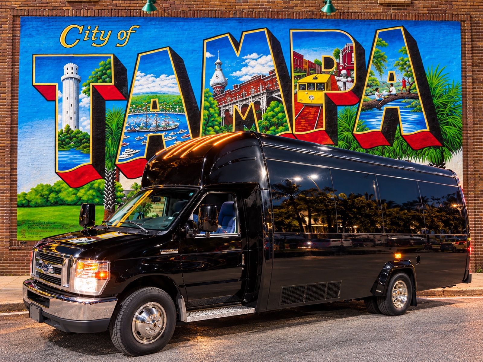 Our black We Live Tampa party bus parked in front of the City of Tampa mural